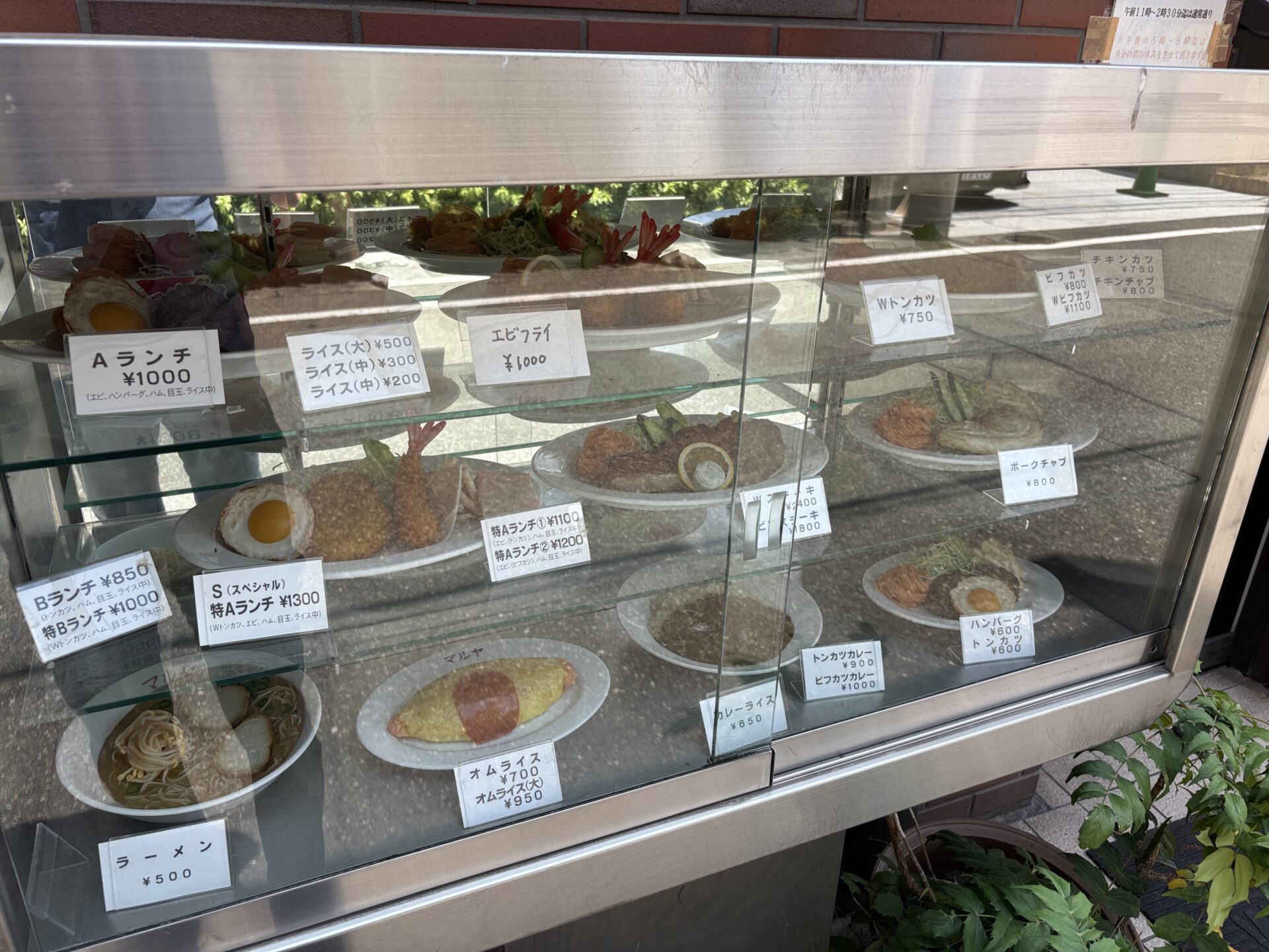 Aランチやオムライスなどの食品サンプルが並ぶマルヤ食堂のショーケース