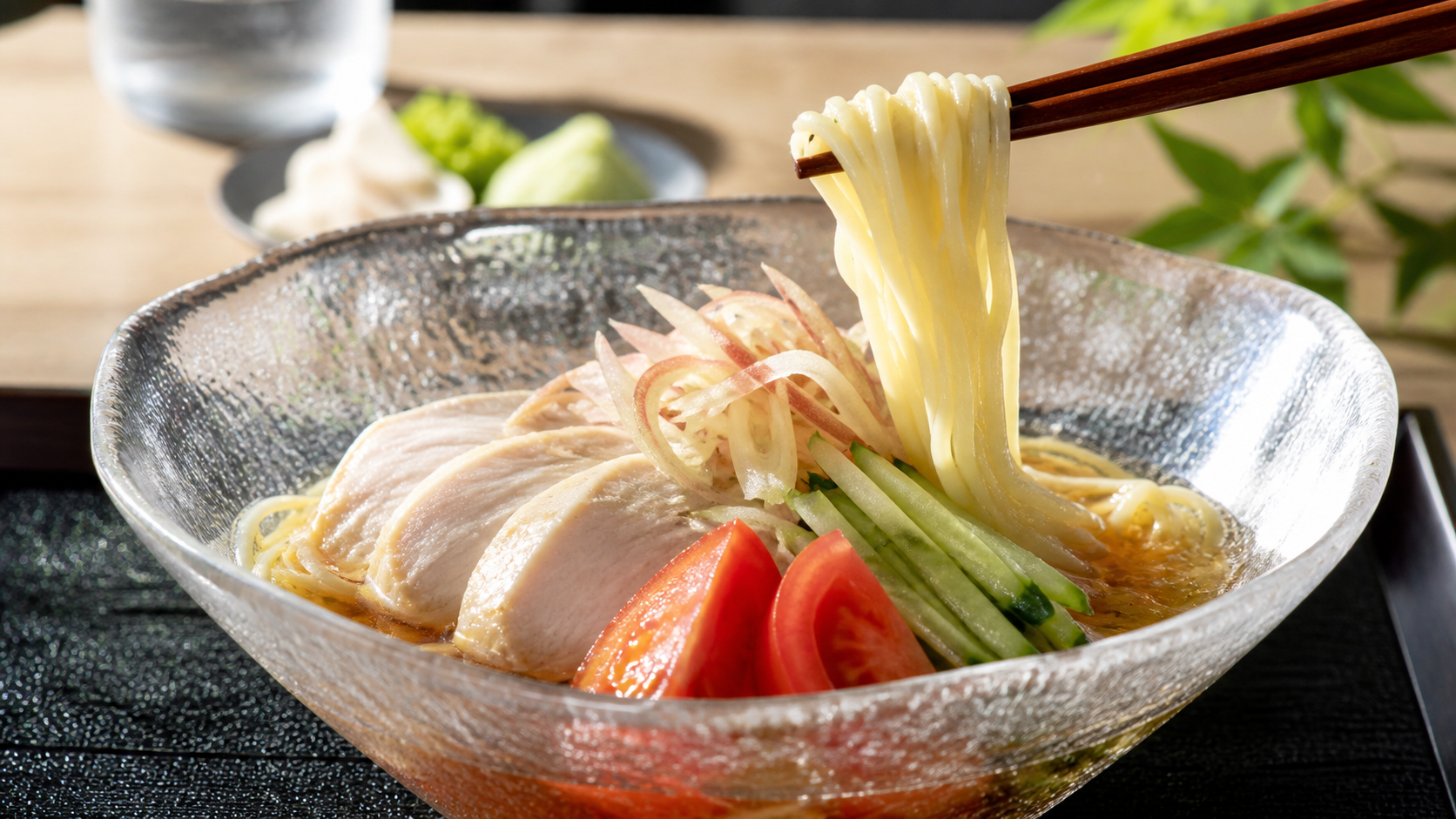 透明な冷たいスープから麺を持ち上げた冷やしラーメン