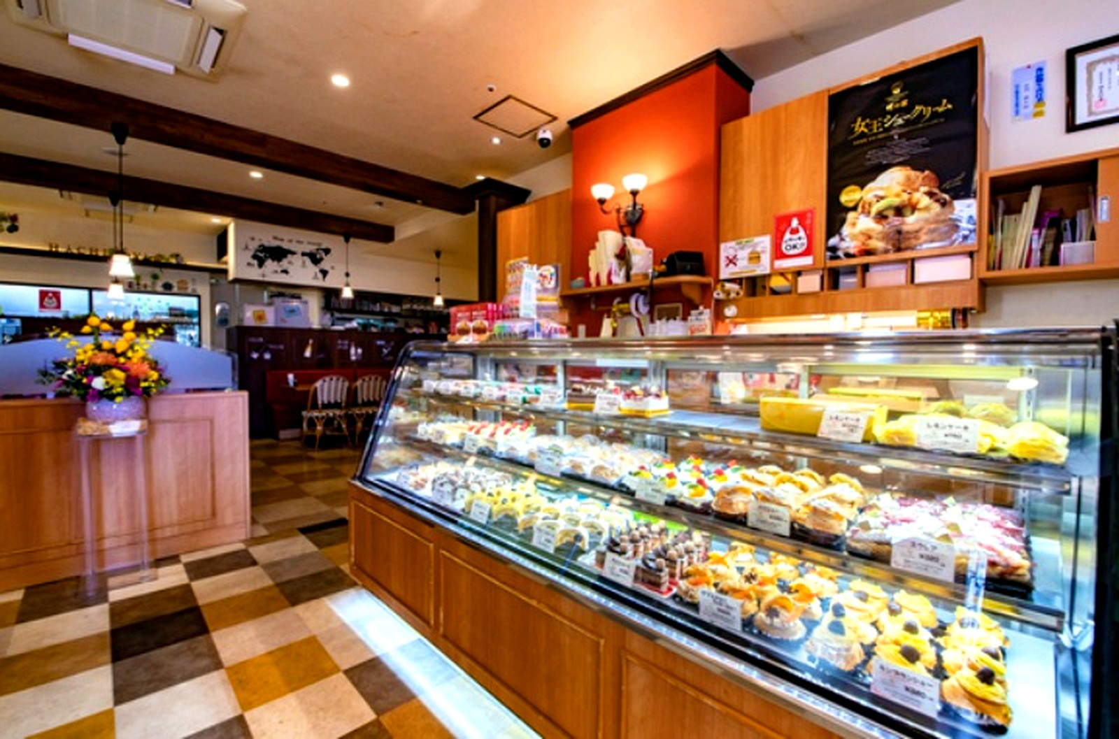 女王シュークリームのポスターが飾られた蜂の家の店内とケーキのショーケース