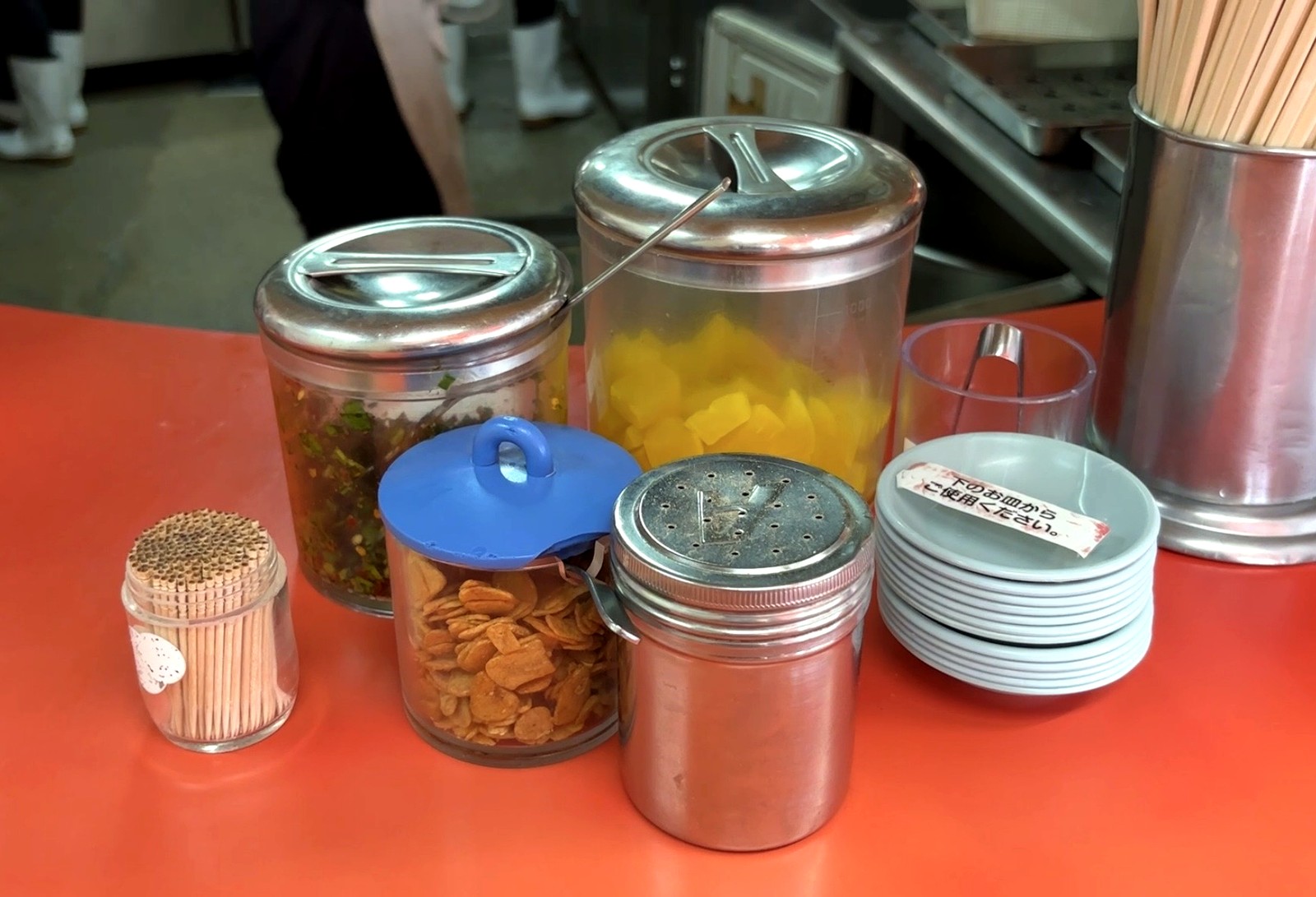 にんにくチップやニラなど無料の薬味が並ぶもっこす石屋川店のカウンター