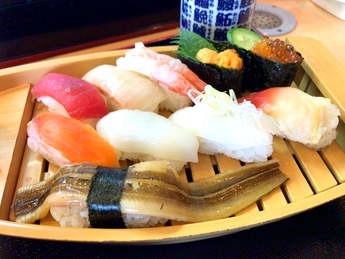 魚河岸寿司の船盛りにぎり 木の舟皿に盛られた本マグロやウニなどの豪華なにぎり寿司