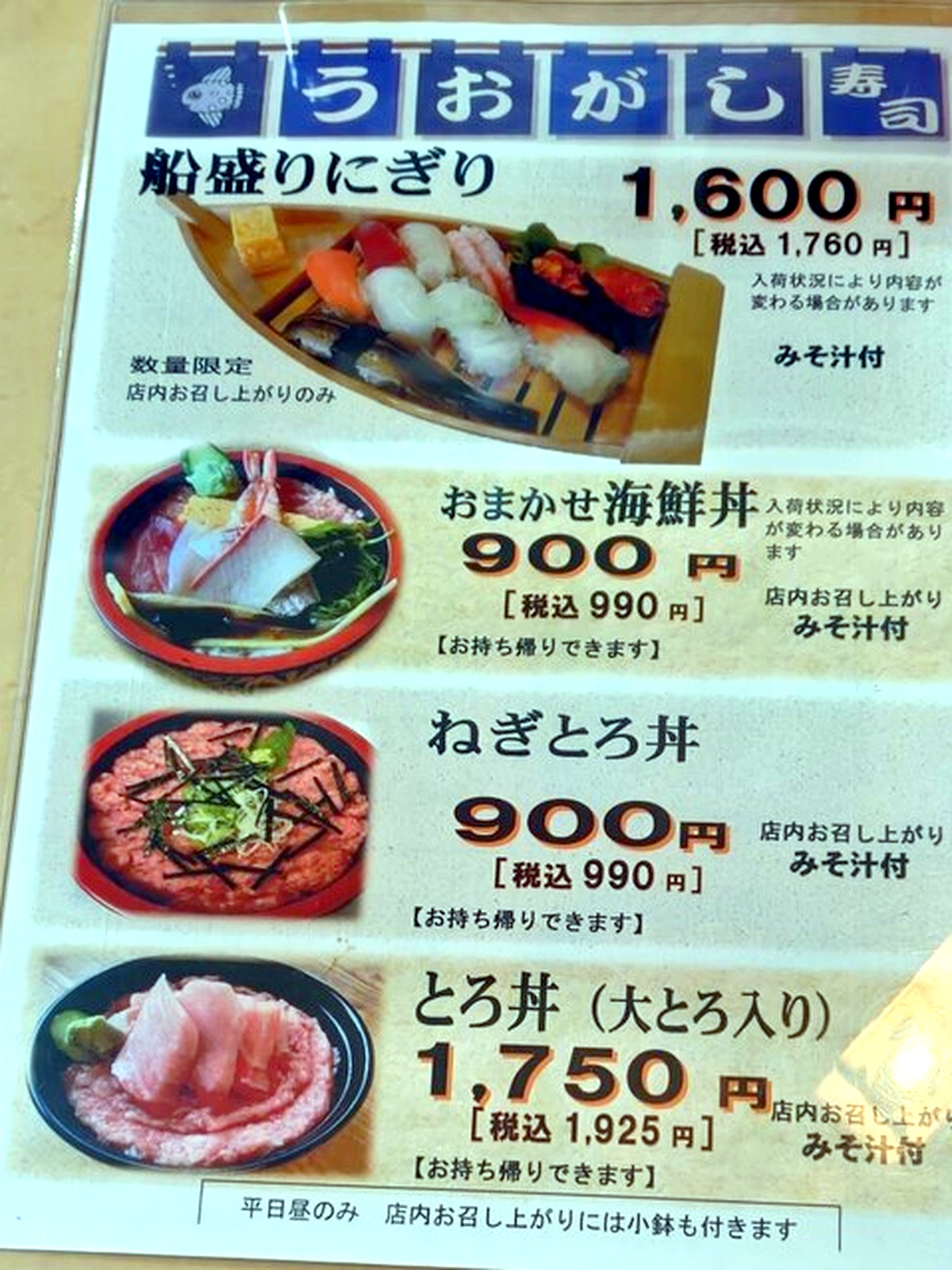 魚河岸寿司の店頭メニュー看板 おまかせ海鮮丼990円ととろ丼の写真入り価格表